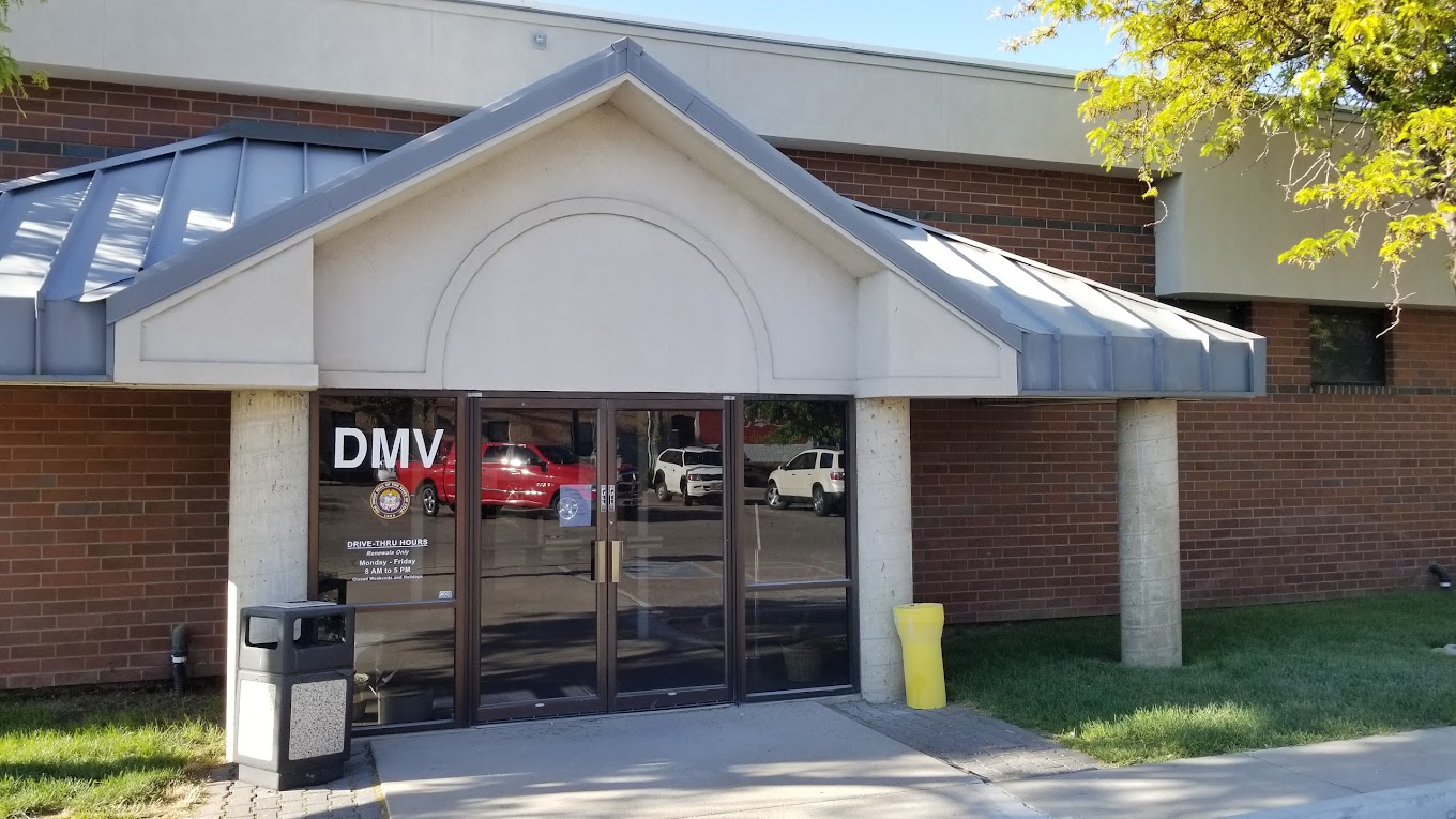Brick DMV building entrance with gabled portico and glass doors
