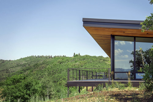 Modern hillside cabin with cantilevered deck overlooking the foothills