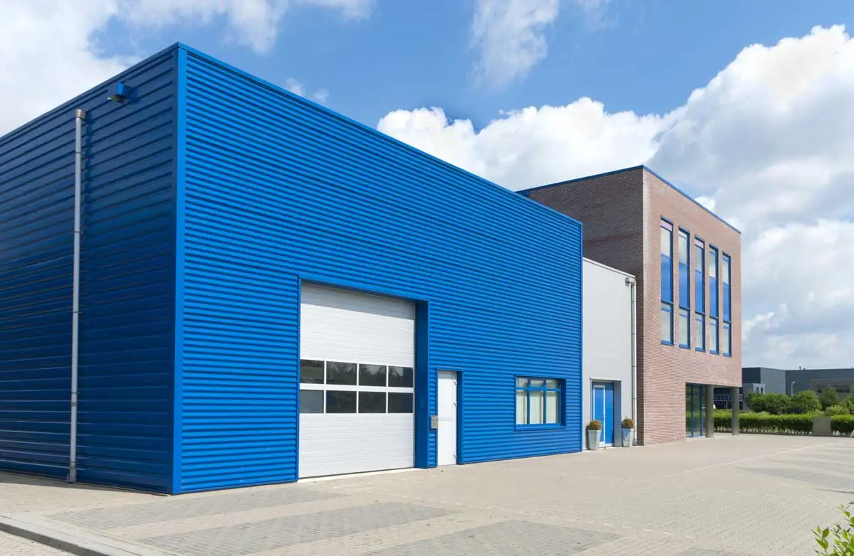 Modern blue-clad industrial warehouse with overhead loading door