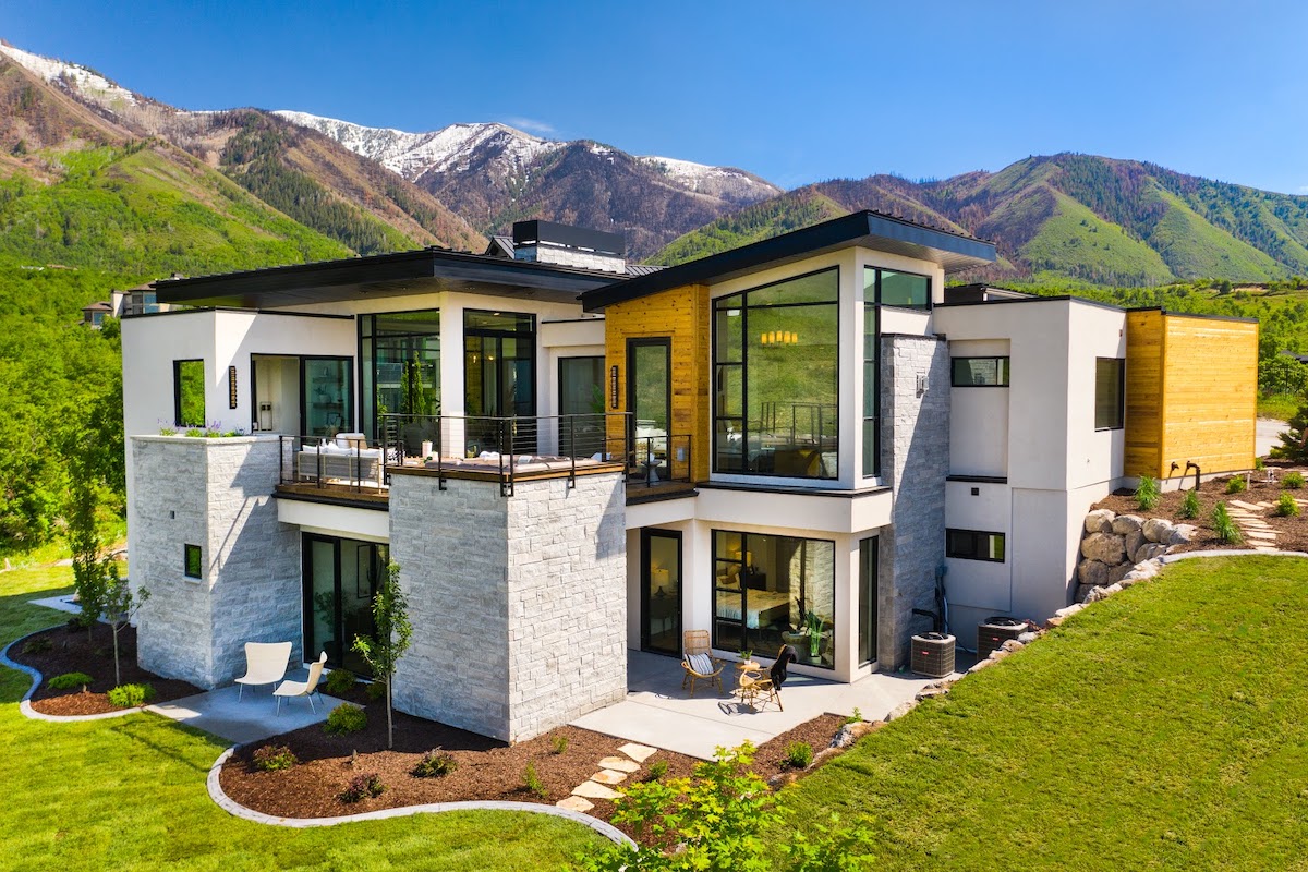 Modern mountain estate with stone, wood, and glass against the Wasatch Range