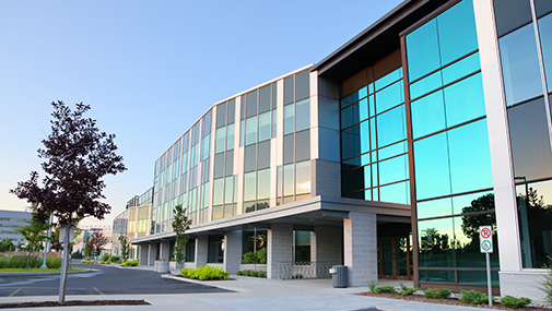 Three-story glass-front office building with reflective curtain wall