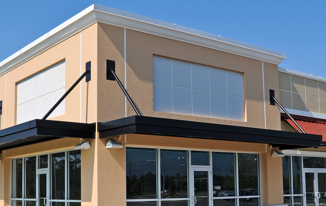 Modern retail corner storefront with awnings and large windows