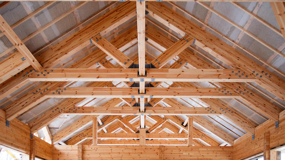 Exposed engineered wood roof trusses with steel plate connectors during framing inspection